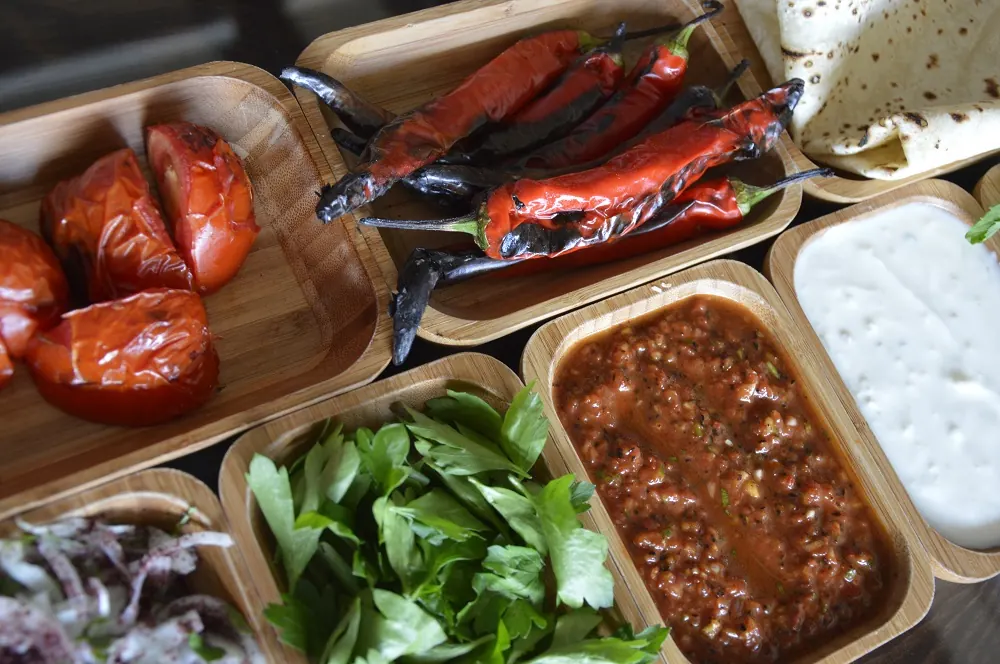 Kebap ikram sofrası: közlenmiş biber, domates, acılı ezme, maydanoz ve lavaş